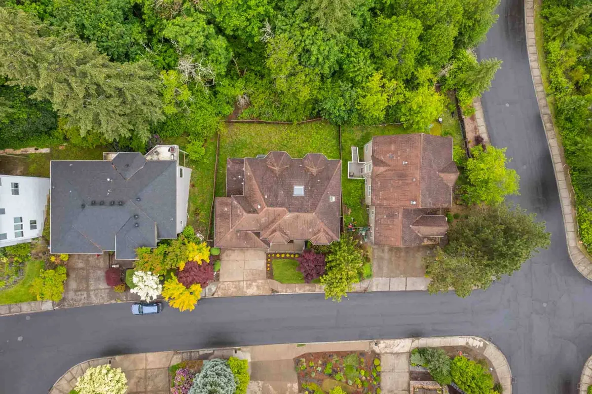A view of residential homes surrounded by abundant greenery, tidy gardens, and open lawns. The image radiates a sense of community and outdoor leisure, with inviting spaces perfect for dog walks and play.